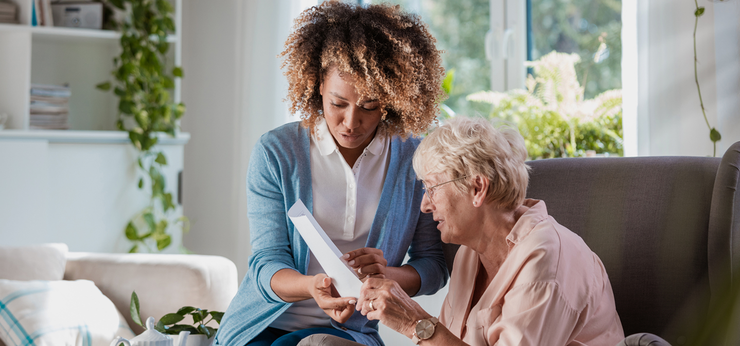 A caregiver and senior reading together at home in Alabama